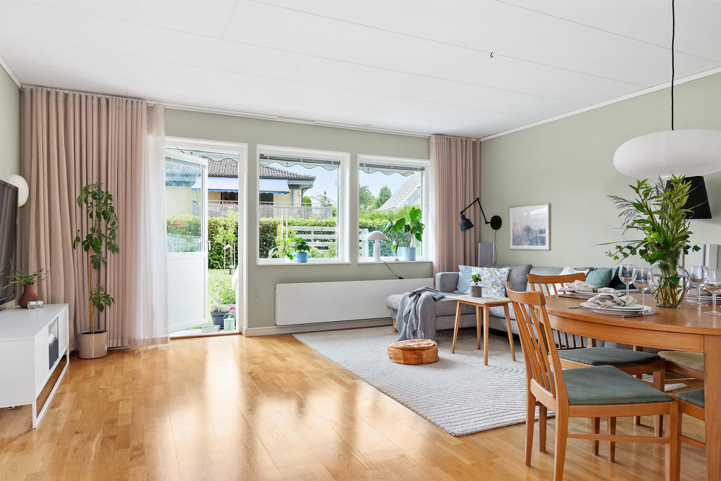 Rymligt vardagsrum med utgång till uteplats och trädgård