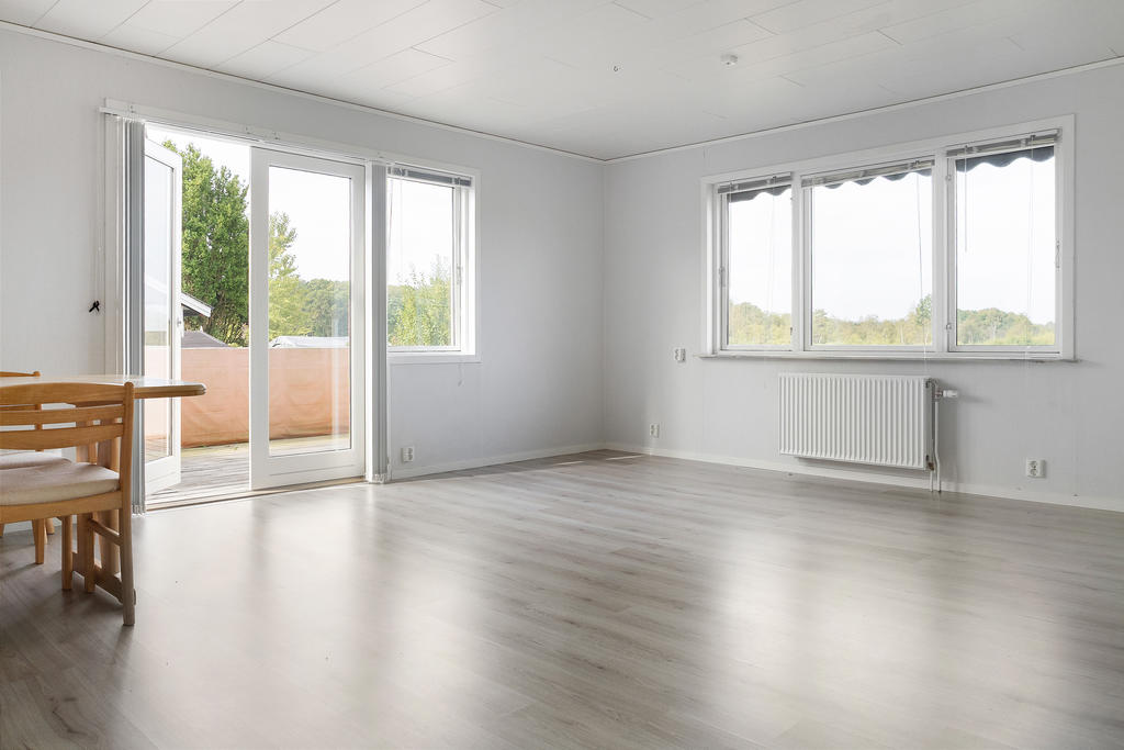 Stort ljust vardagsrum med utgång till tralldäck i söderläge