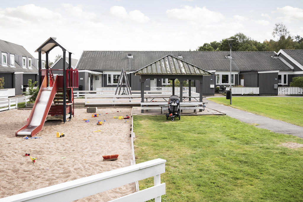 Lekplats och grönyta som omgärdas av bostadshusen