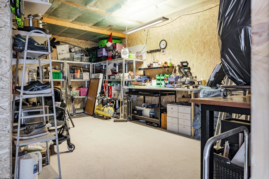 Stort rum innanför carport. Hobbyrum, extra förråd eller mindre verkstad. 