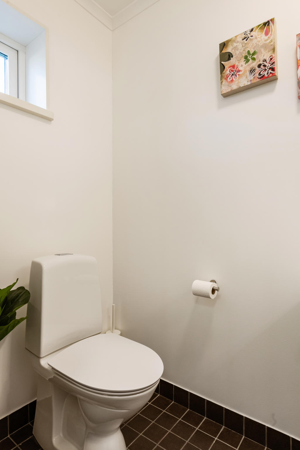 Välkomnande generös hall med klinker på golvet och ljusa väggar. Här finns  utrymme för både skor och ytterkläder, samt att det även finns en gästtoalett. 
