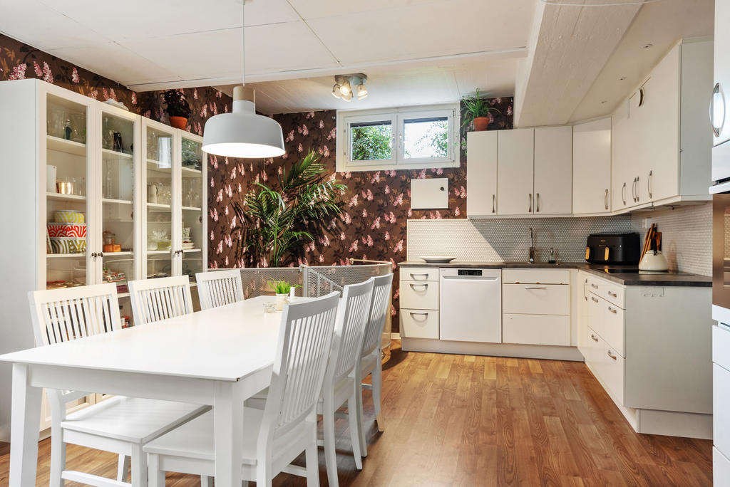 Generöst kök med gott om förvaringsutrymmen, arbetsytor och plats för ett rejält matbord.