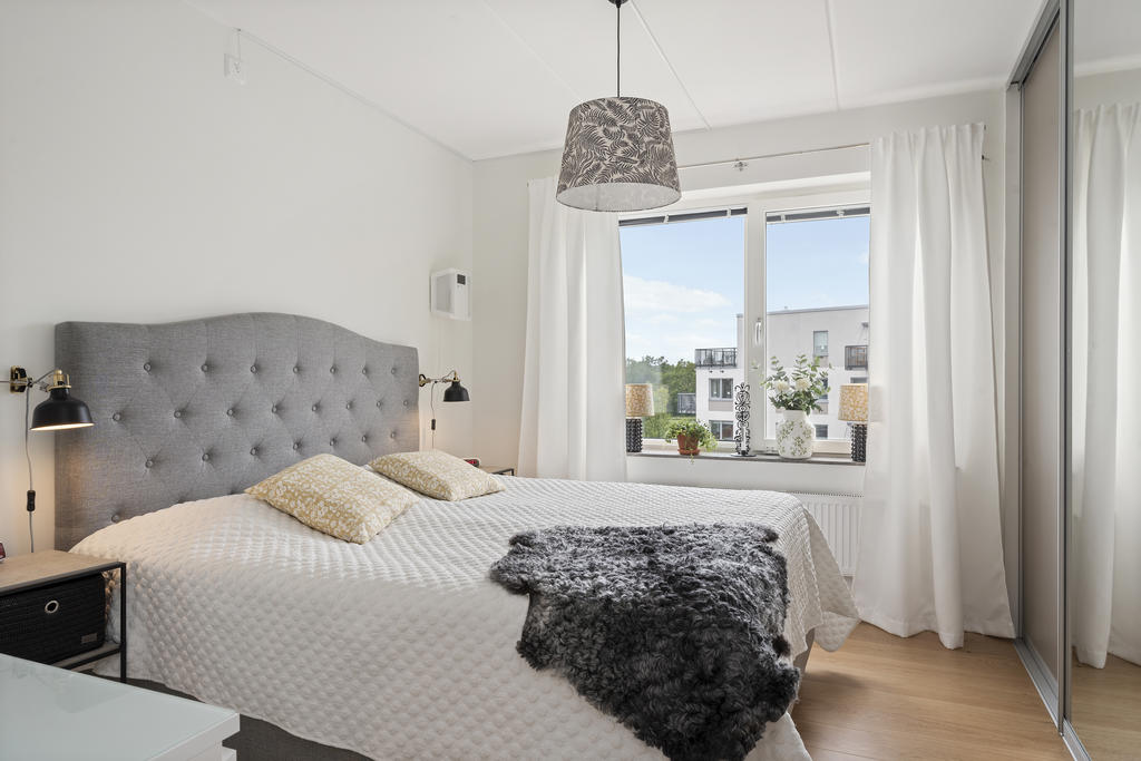 Stort ljust master bedroom med rymlig skjutdörrsgarderob