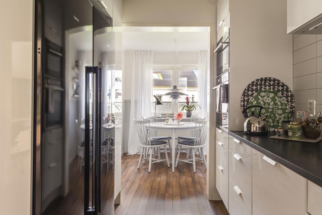 Här finns gott om förvaring bakom vita, klassiska skåpluckor och utrustningen består av kyl, frys, spis, fläkt och diskmaskin. 