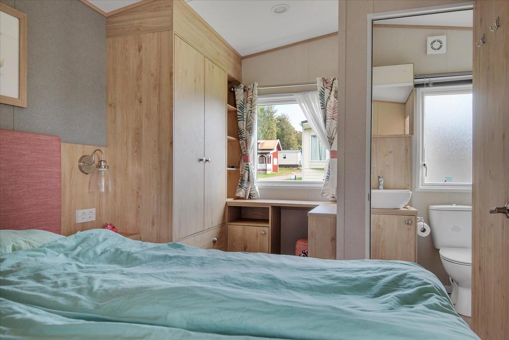 Master bedrom med vy mot kontorshörna och badrum