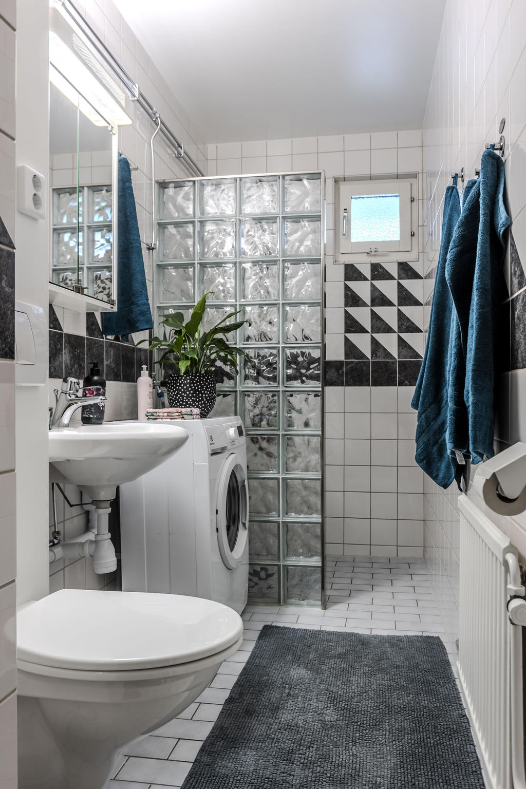 Rymligt helkaklat badrum med tvättmaskin