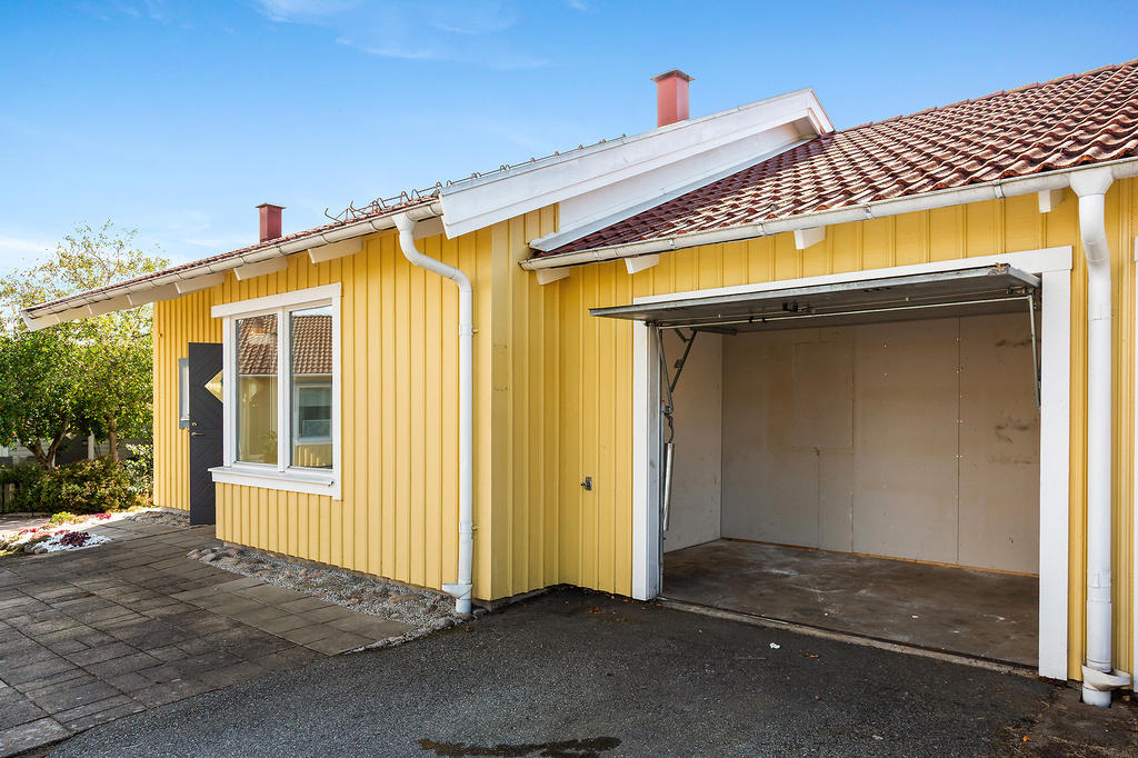 Stensatt uteplats på framsidan och förråd fd. garage