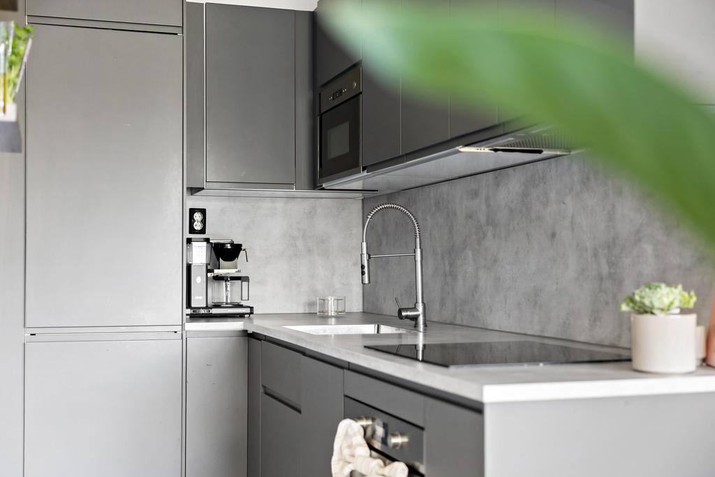 Tidlöst och stilrent kök med integrerad diskmaskin och kyl/frys.