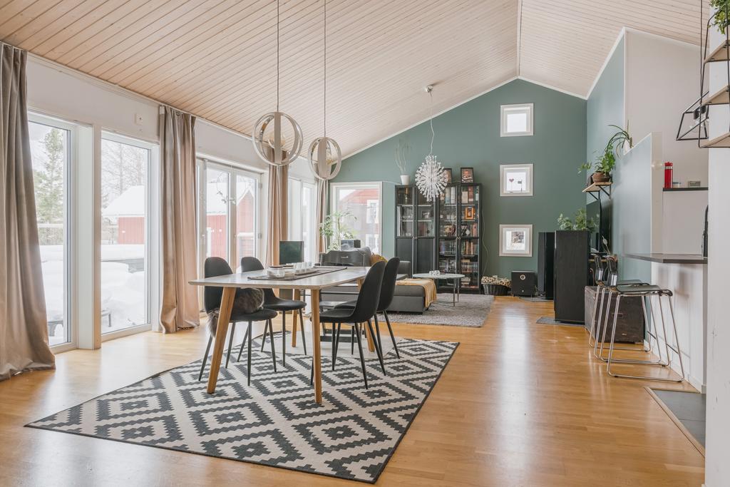 Matrum/vardagsrum med högt i tak och stora fönsterparter mot altanen
