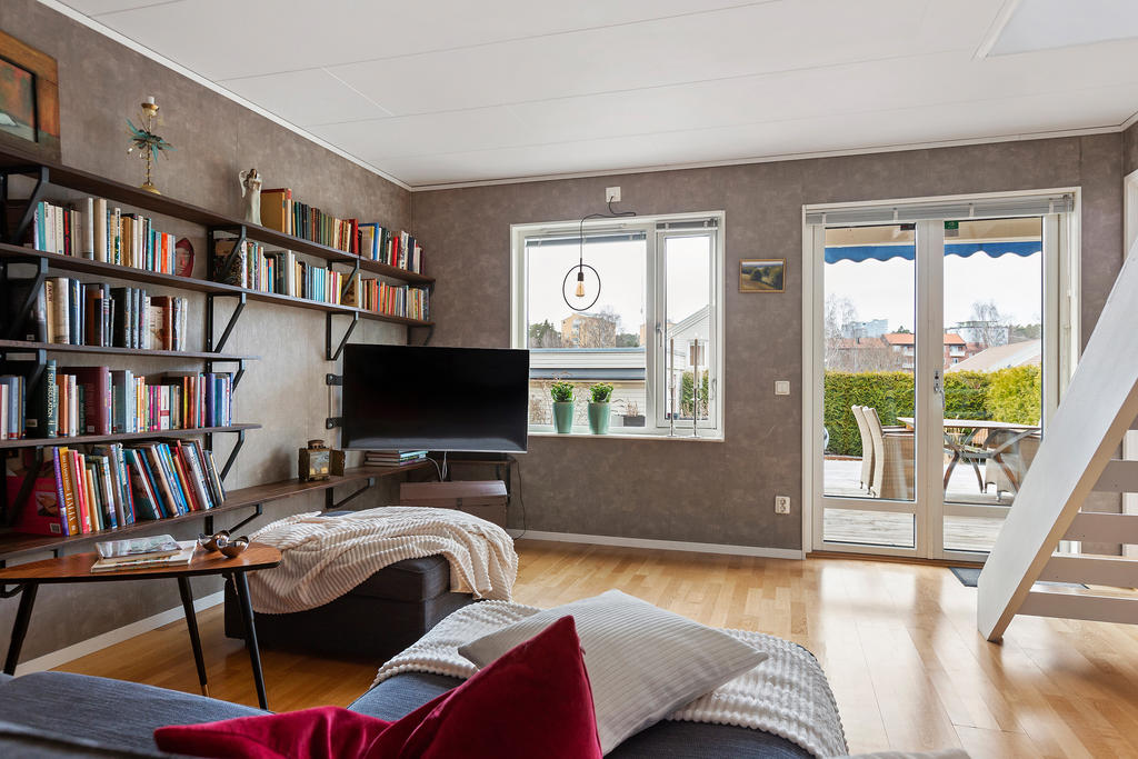 Stort allrum i suterräng plan med utgång till altan och trädgård