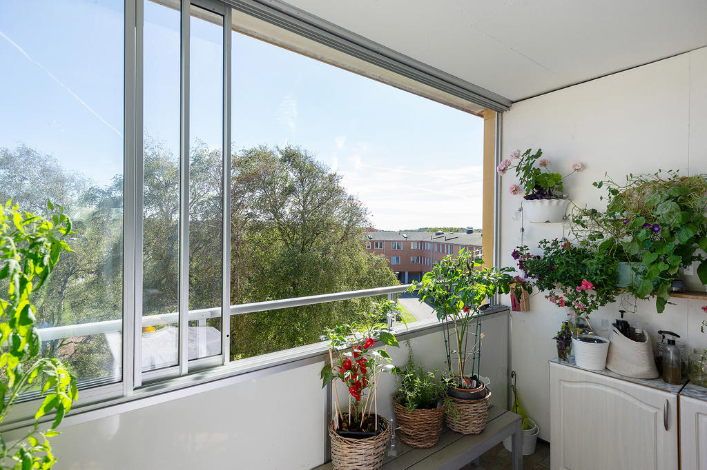 inglasad balkong med utsikt över föreningens grönskande innergårdar!