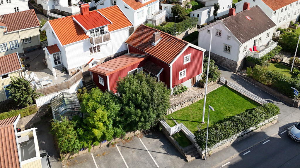 Växthus, lummig trädgård med uteplatser och fyra parkeringsplatser.