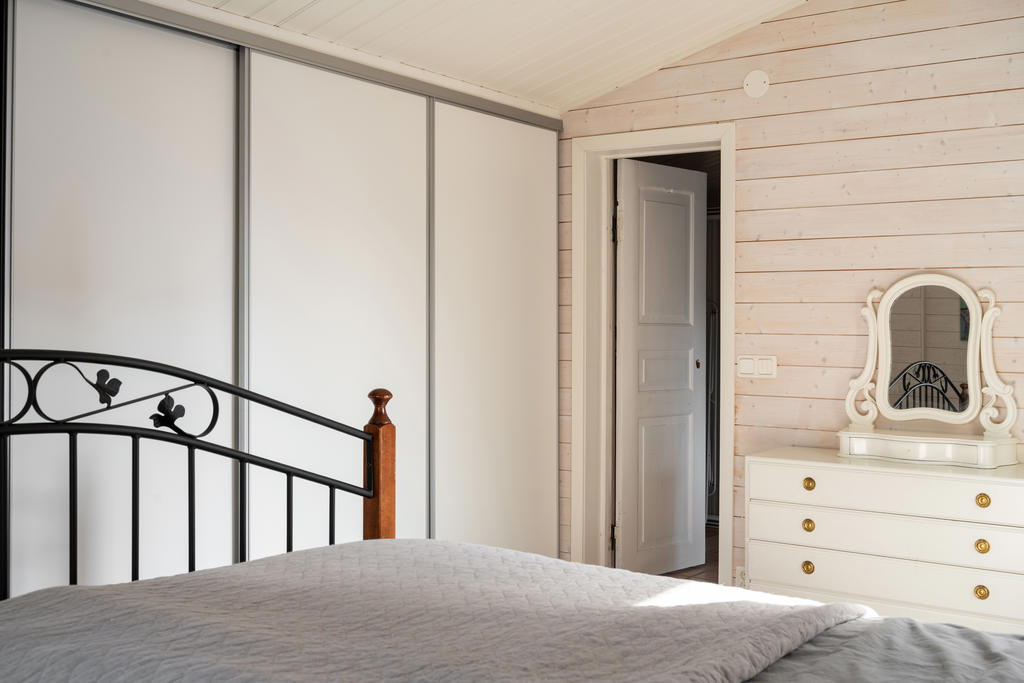 Master bedroom med bra garderobsförvaring bakom skjutdörrar.