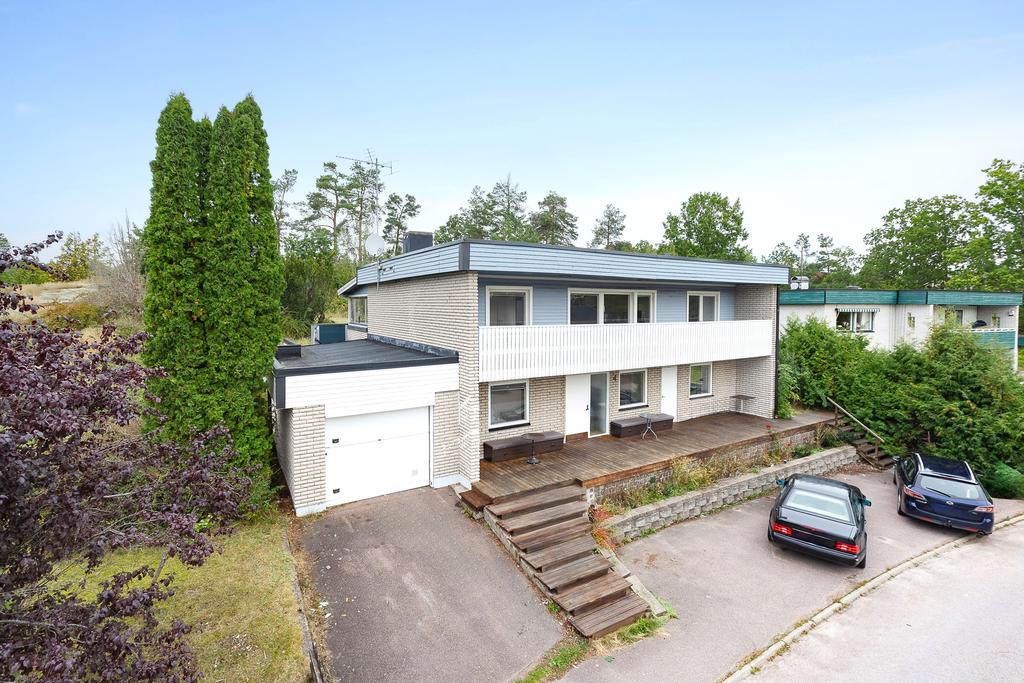 Fasad med uppfart och garage, stor terrass och balkong