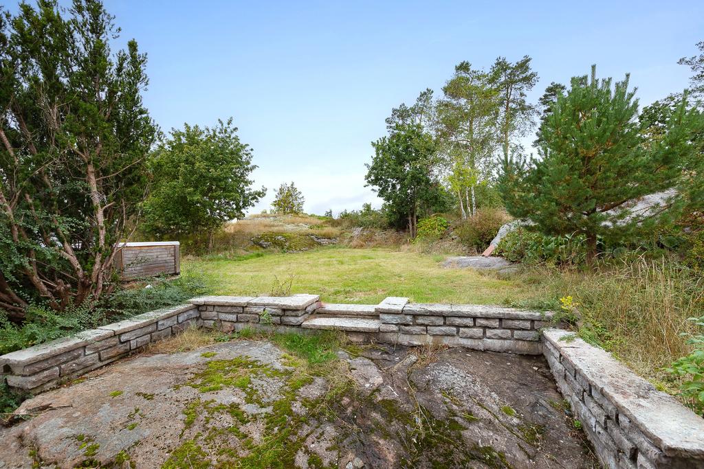 Berggrund på baksidan samt insynsskyddad gräsmatta