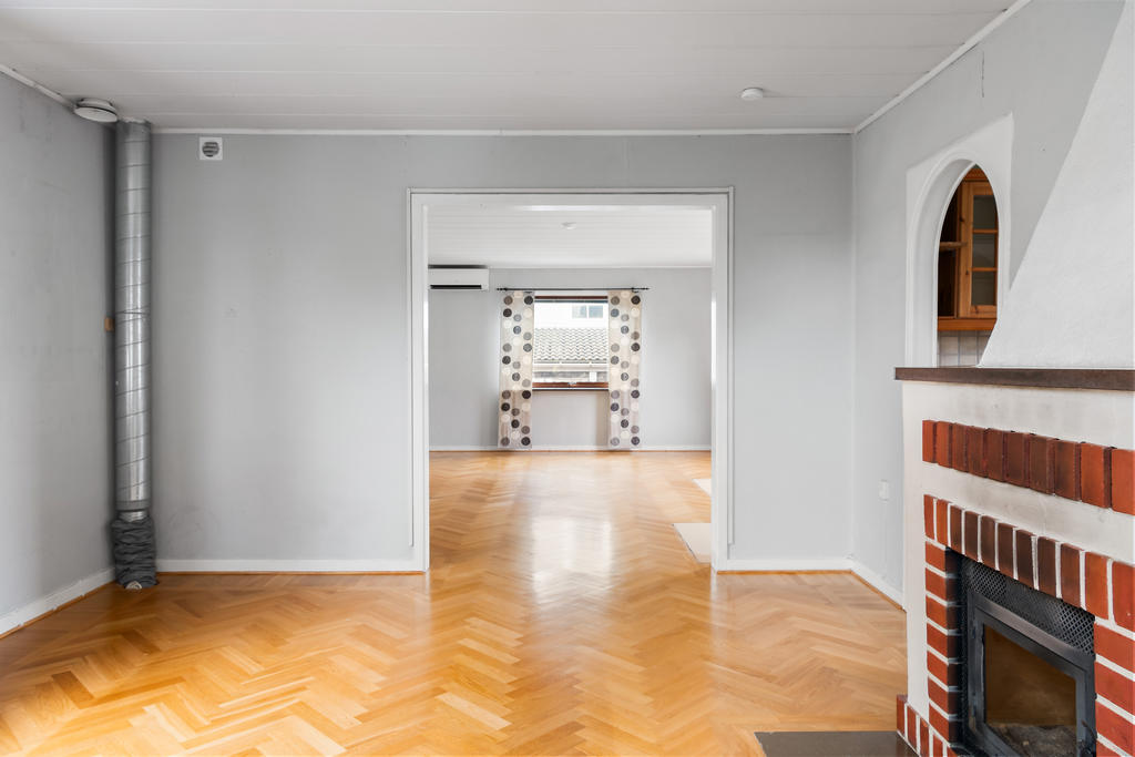 Stort vardagsrum i två delar med genomgående ljus. 