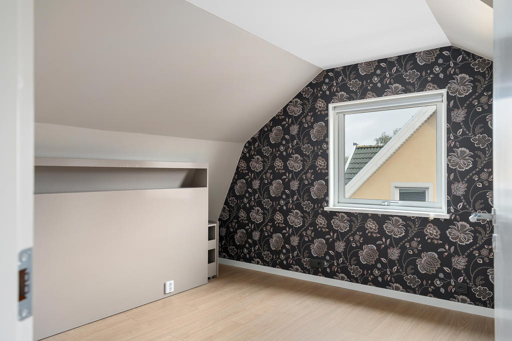 bostadens största sovrum med fast sänggavel och inbyggda garderobslösningar. 