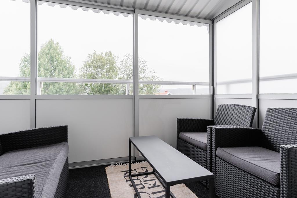 Inglasad balkong med plats för både loungegrupp och matbord
