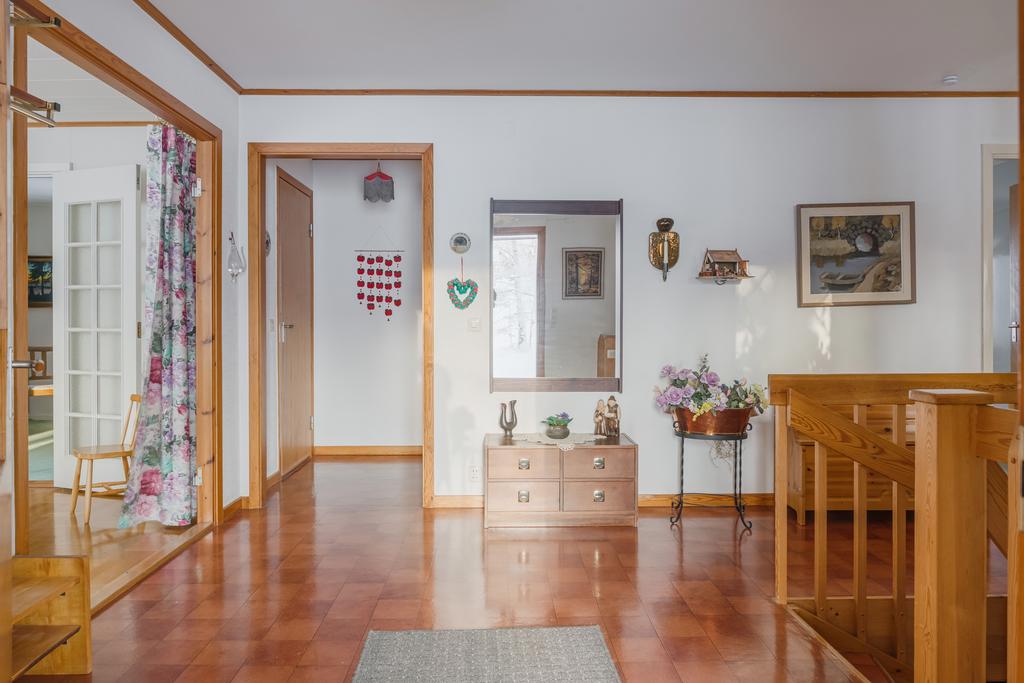 Från entrén med vardagsrum till vänster och badrum och extra ingång till salongen/biblioteket rakt fram.