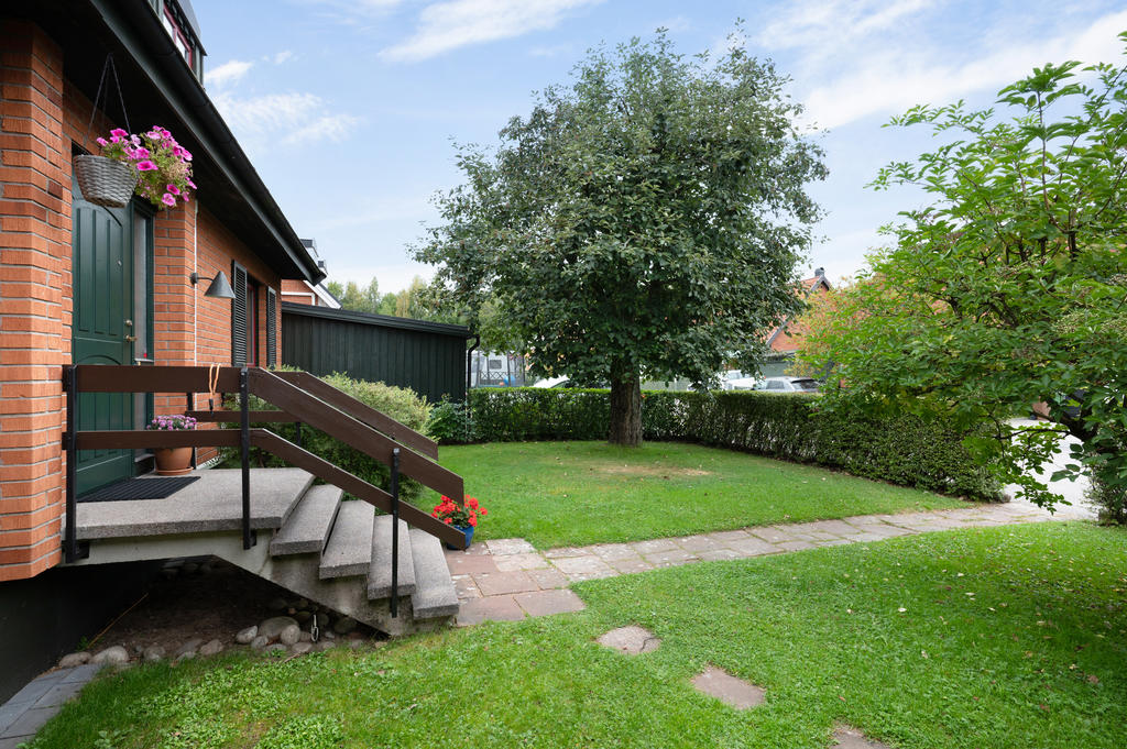 Entré med stenläggning och gräsyta