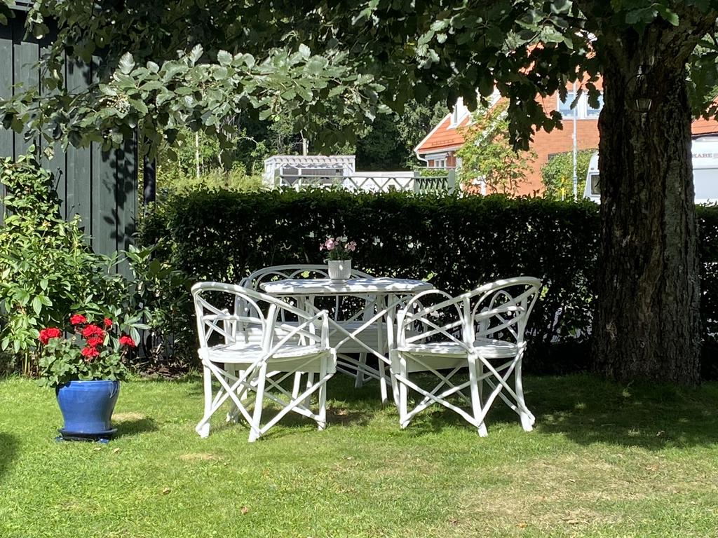 Säljarnas bilder - Sommarbild med en möbelgrupp under trädet vid entrén