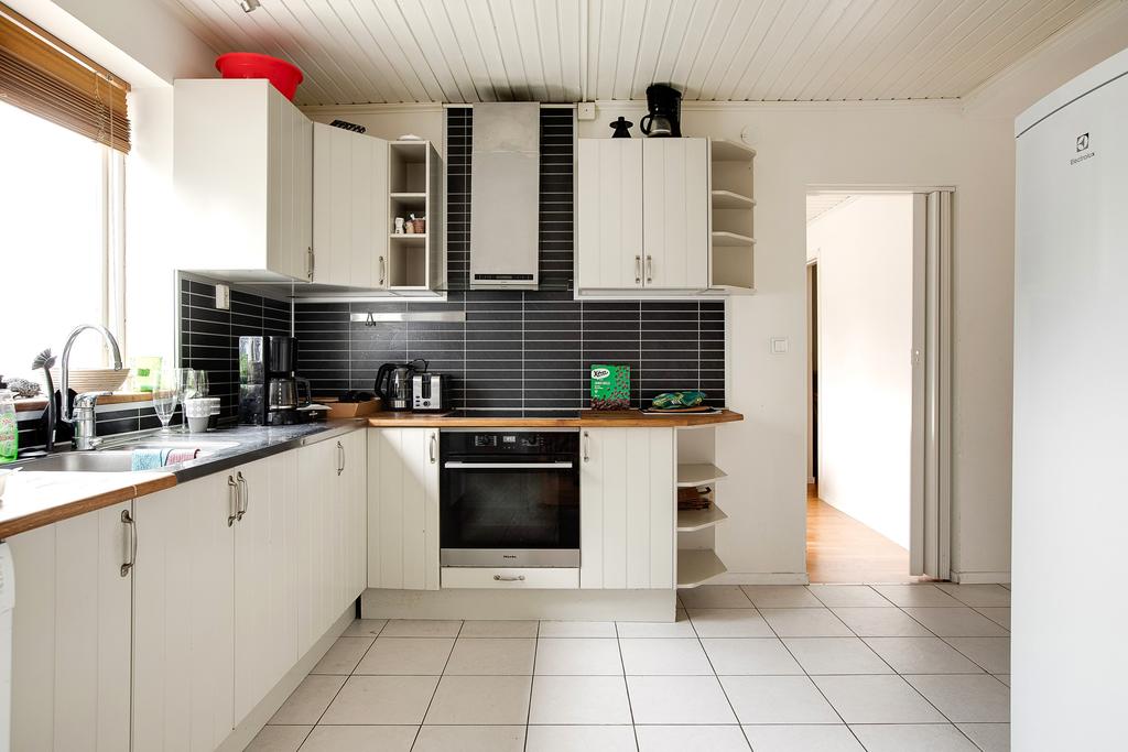 Kök med diskmaskin, stor kyl och frys samt integrerad spis och häll