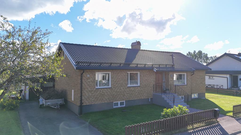 Vidbyggt garage med asfalterad uppfart framför.