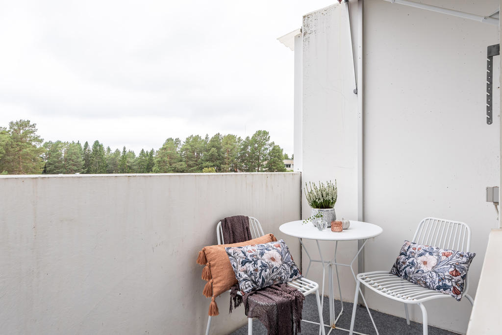 Balkong med kvällssol och vy mot gården.