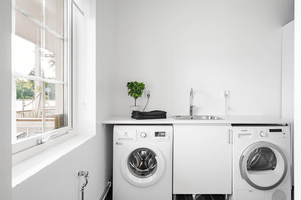 Tvättstuga med tvättmaskin från Electrolux och torktumlare från Siemens