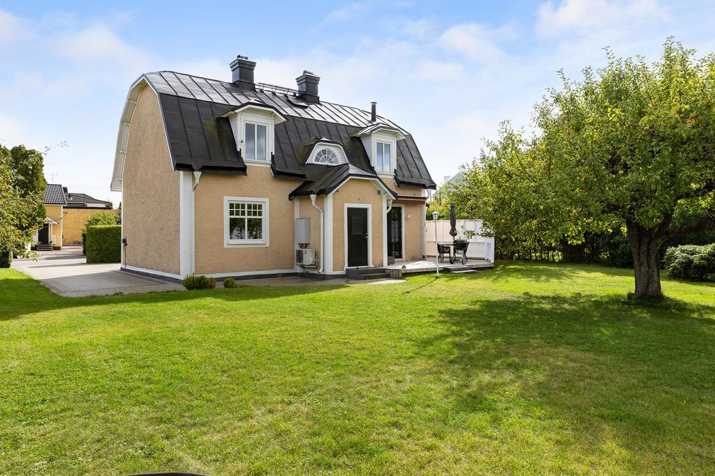 Grönskande insynsskyddad trädgård. Uteplats i västerläge. 