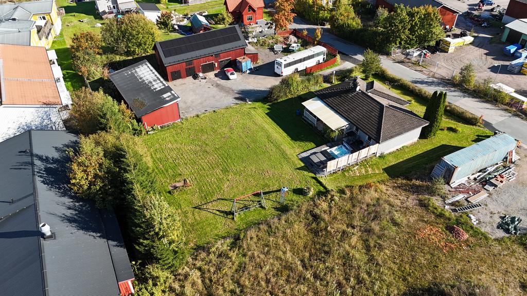 Drönarfoto, baksida med takad altan samt jaccuzzi. Garage och verkstad.