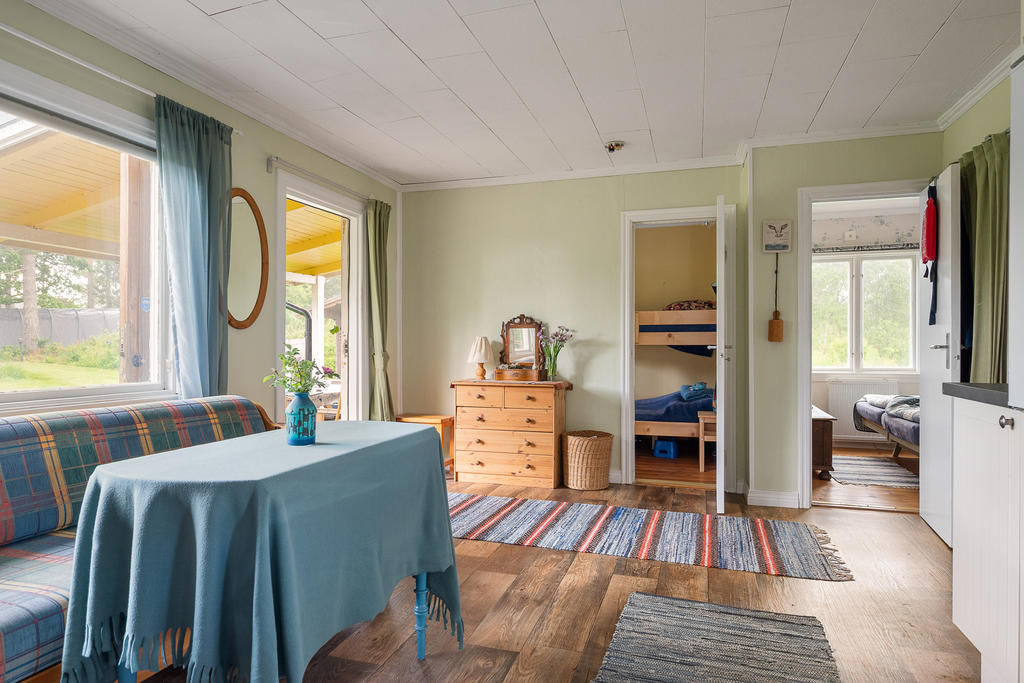 Luftig hall med soffa och ingång till de båda sovrummen