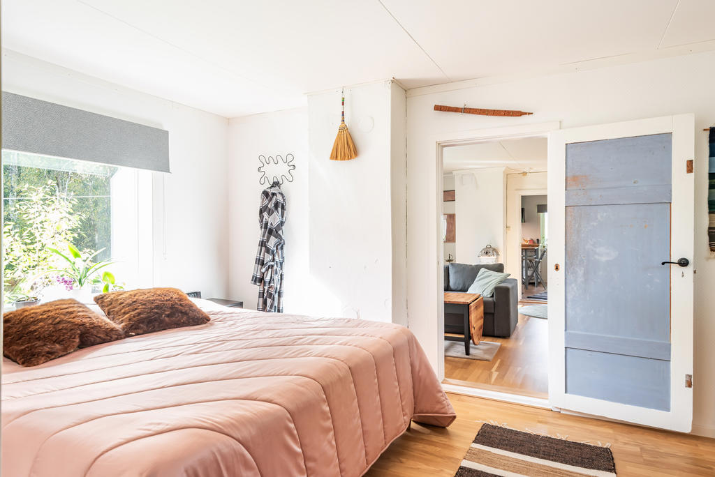 Sovrum med vy mot vardagsrum och kök