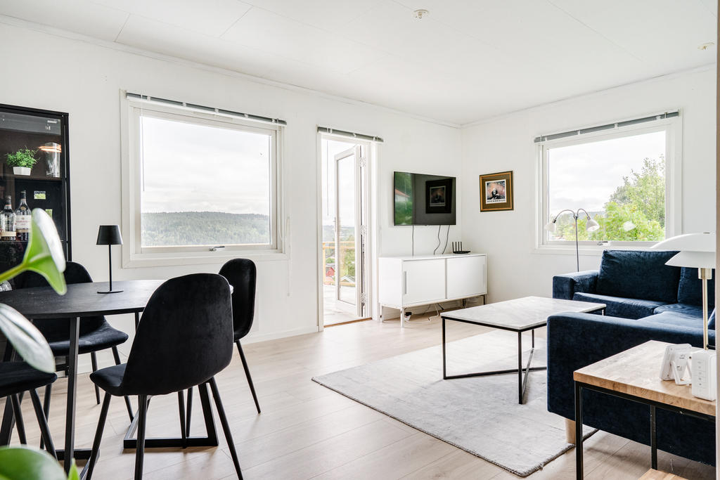 Hemtrevligt vardagsrum med fräscha ytskik toch utgång till renoverad altan.