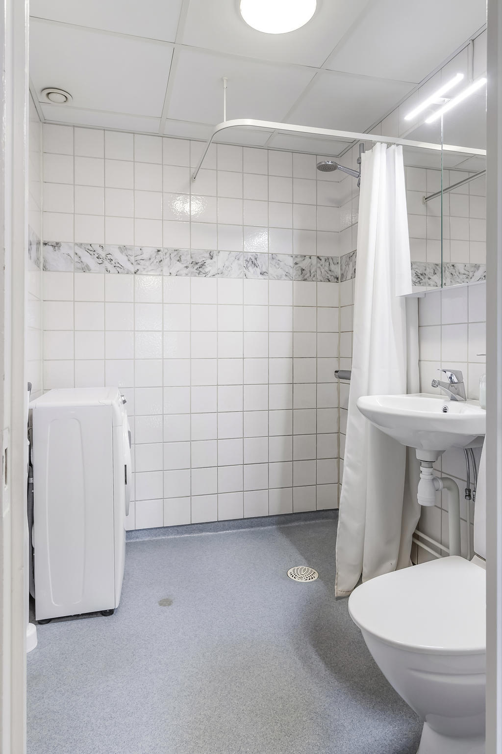 Badrum med dusch och tvättmaskin