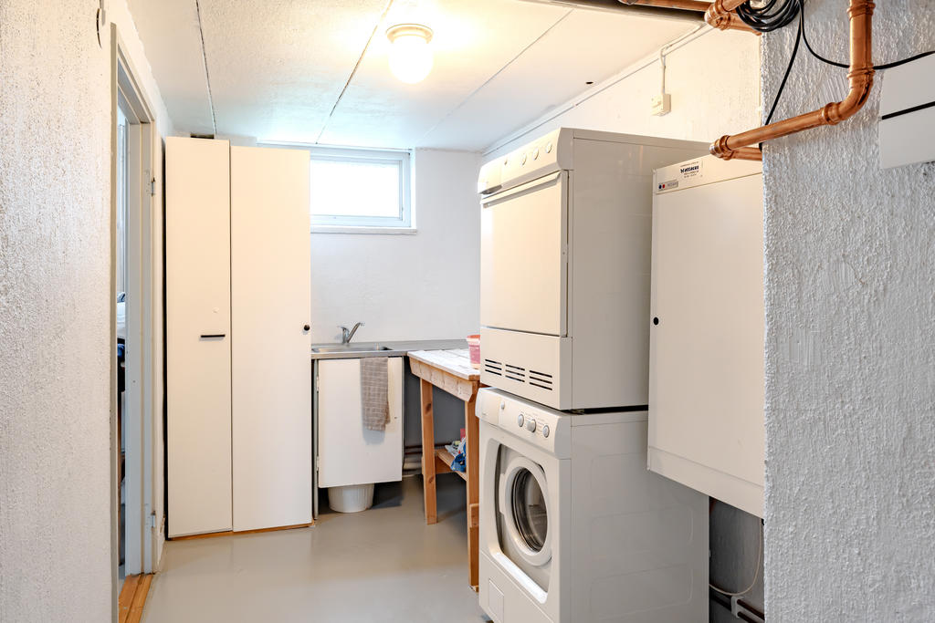 Tvättstugan har tvättmaskin, tumlare, tvättho och förvaring.