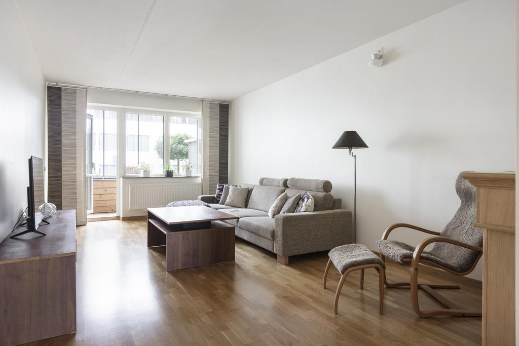 Stort vardagsrum med utgång till den inglasade balkongen/uteplatsen.