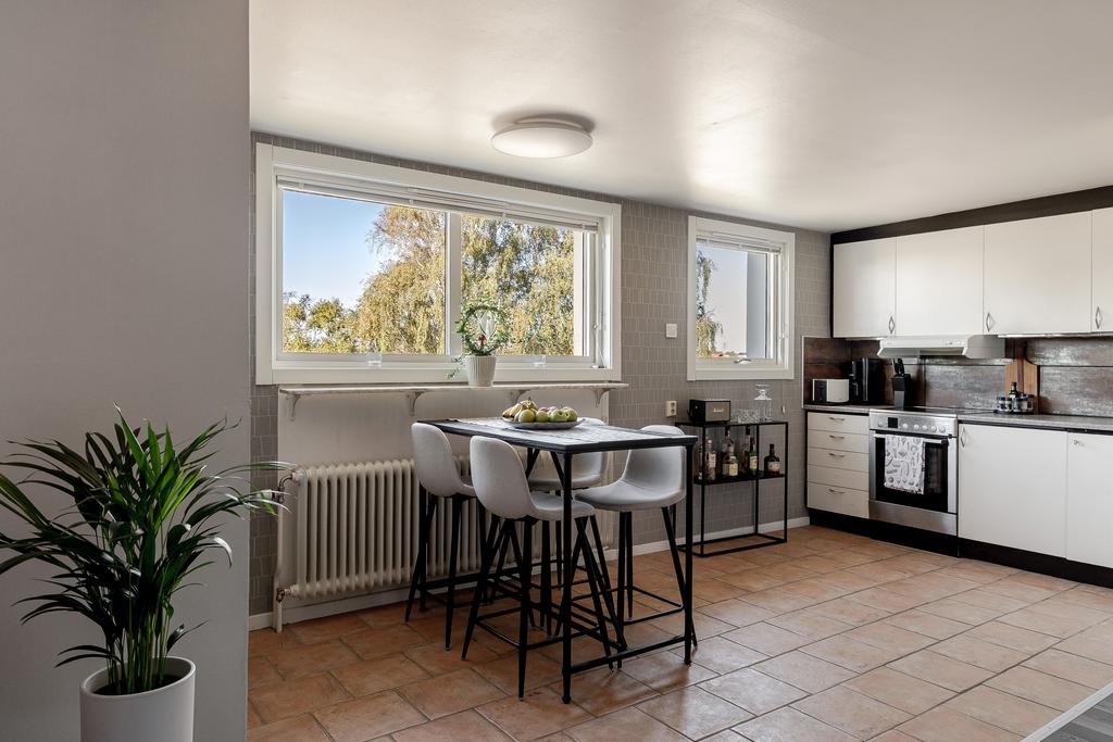 Ljust och luftigt kök med stora fönster som släpper in härligt dagsljus.