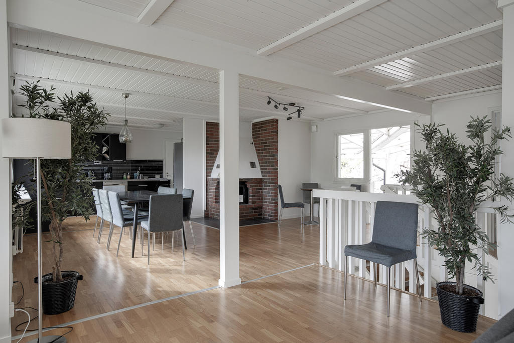 Vardagsrum med altandörr ut till stort trädäck på baksidan av tomten