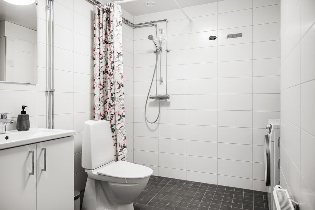 Modernt och fräscht badrum med tvättmaskin