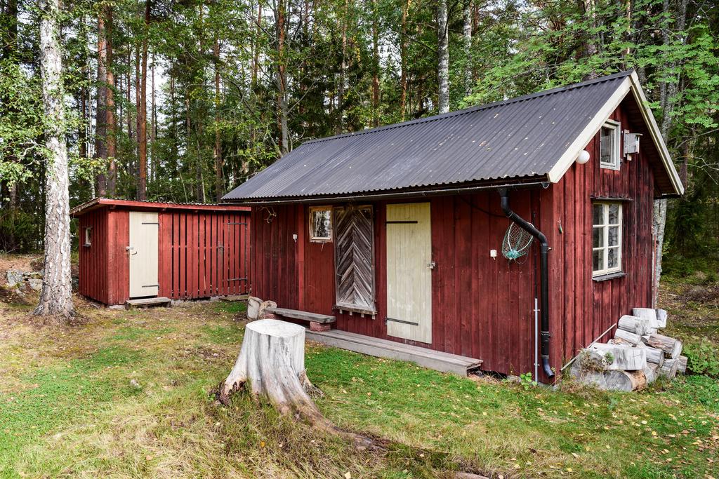 Förråd med vedbod och "dass" med förbränningstoalett