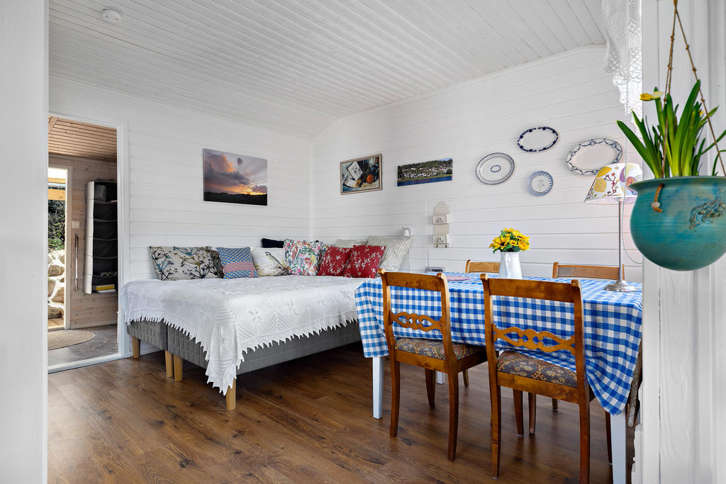 På insidan i stugan är väggarna ljusa och golven enhetliga. En öppen planlösning men vinklarna ger avskildhet