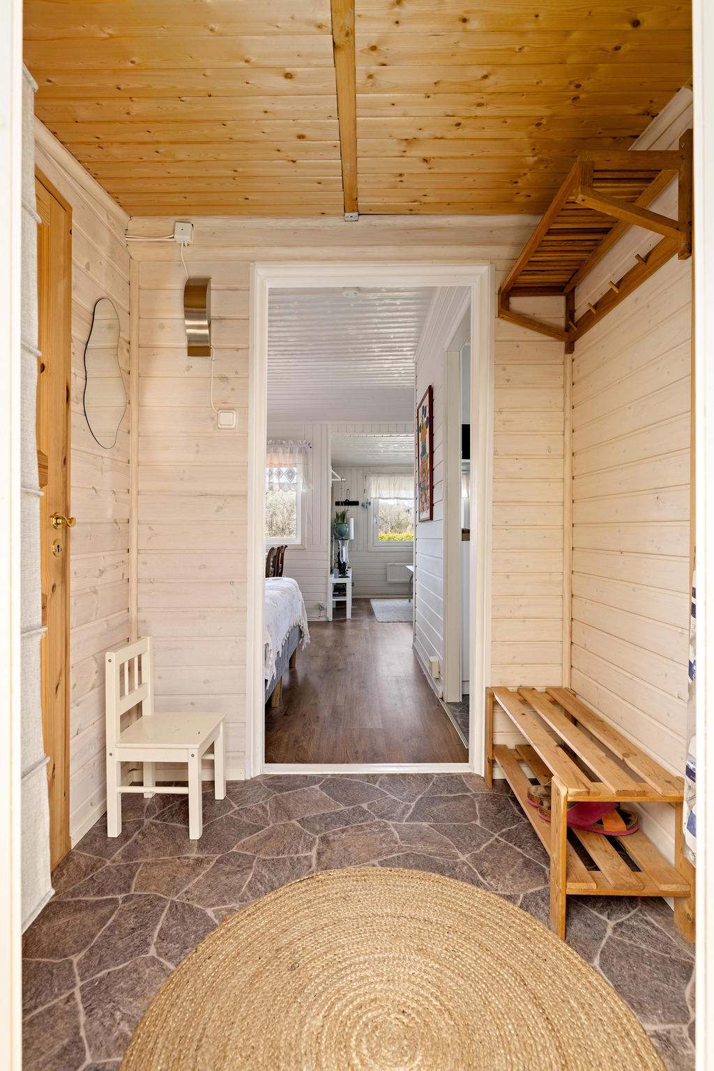 Rymlig entréhall. Till vänster finner ni duschrummet med toalett och till höger ett förrådsrum