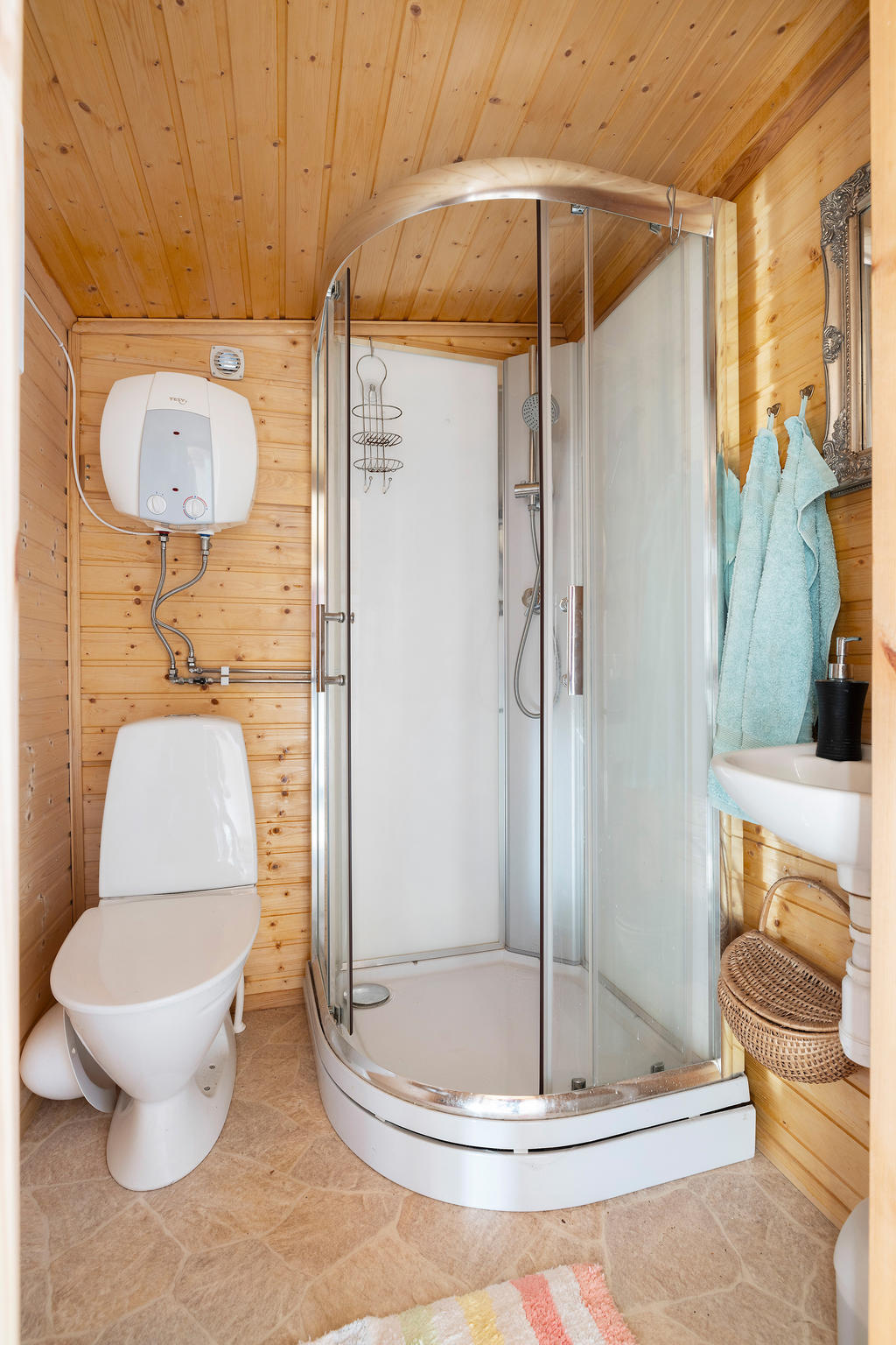 Duschrum med duschkabin, toalett, handfat och varmvattensberedare