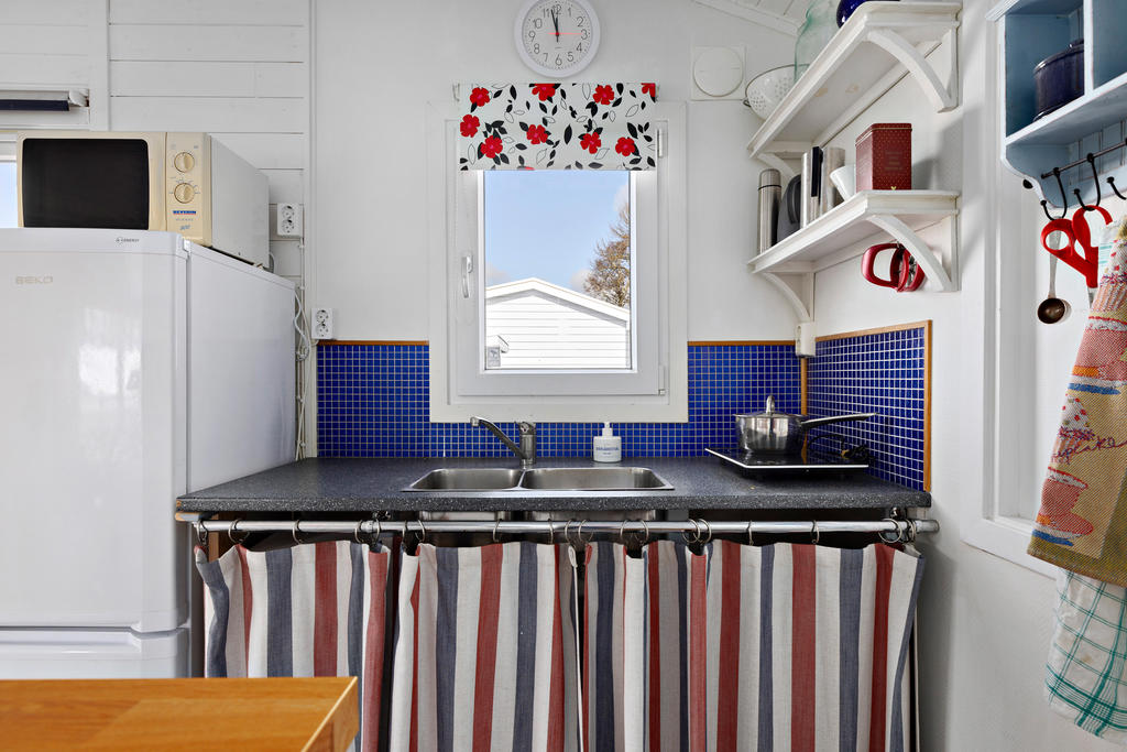 Köket är enkelt men praktiskt utrustad med kyl och frys, portabla kokplattor, diskho, en liten ugn och mikro. Gott om skåputymme. Vädringsfönster. 