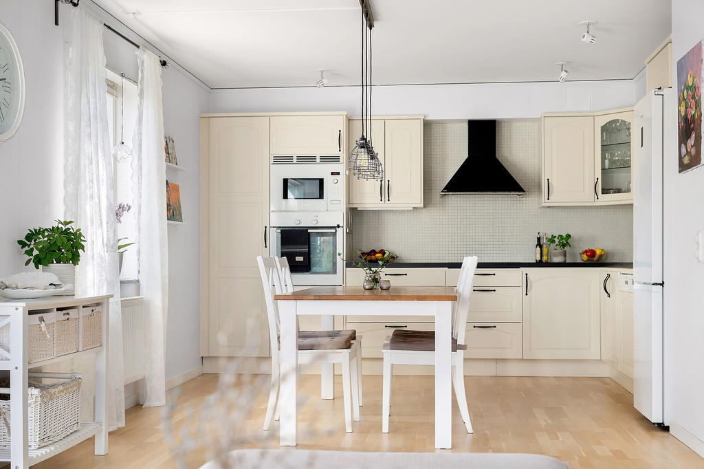 Köket har vita vitvaror och ugn och mikro i arbetshöjd