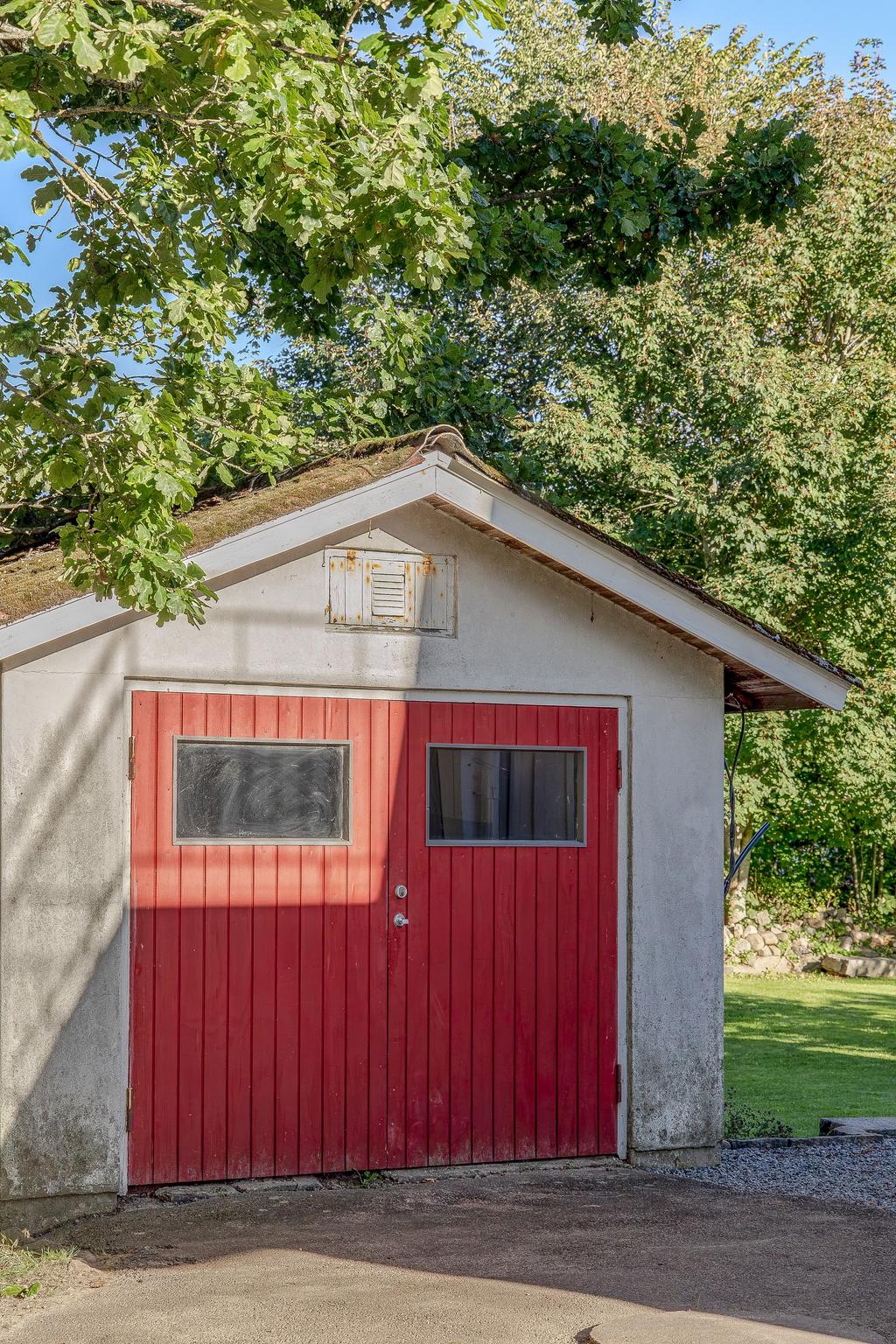 Garaget med de röda portarna som matchar fint till huset
