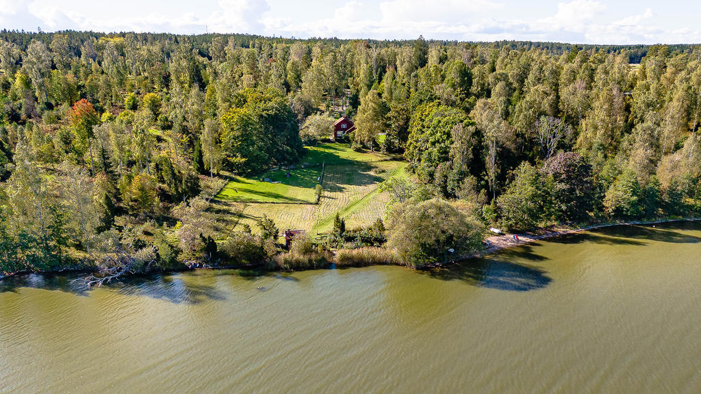 Stora gräsytor och egen sandstrand till höger i bild