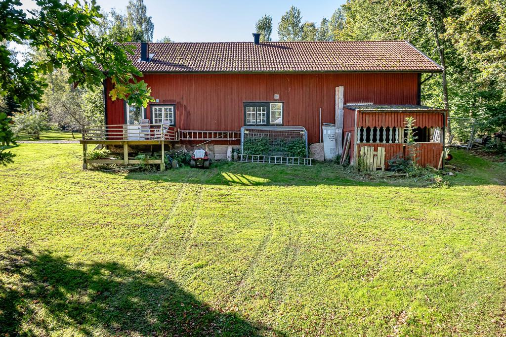 Baksida av f.d. stall med uteplats och vedförråd