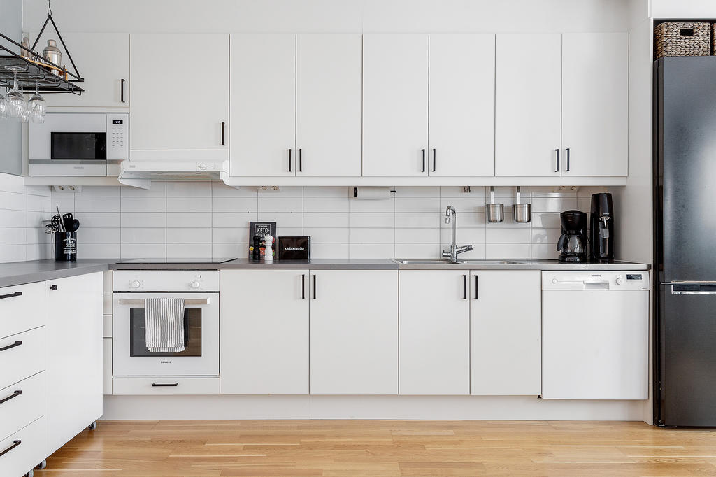 Fräscht kök med detaljersom  handtag och kylf/frys i svart utförande